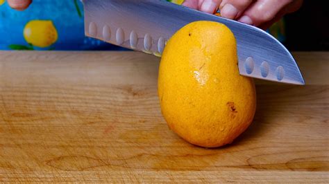 Using the edge of the glass (I like to use a pint glass here, because it’s as tall as the height of a mango and then some), line up the mango so that the glass edge is directly under where the peel and flesh meet, facing the peel out towards your hand. Then, using gentle pressure, slide the mango down, softly pressing your hand and the peel ...